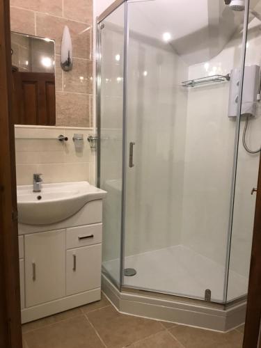 een badkamer met een douche en een wastafel bij The Post House in Ibstock