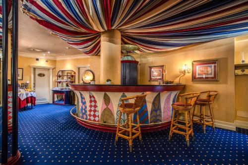 a bar with chairs and a stage in a room at Hotel Auriga in Milan