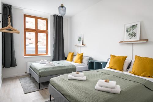 two beds in a room with yellow and green at Komm rein und fühle dich zu Hause direkt nahe der Altstadt Spandau und am Wasser in Berlin