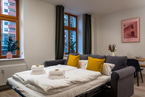 ein Wohnzimmer mit einem Sofa und gelben Kissen in der Unterkunft Komm rein und fühle dich zu Hause direkt nahe der Altstadt Spandau und am Wasser in Berlin