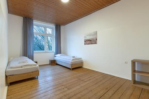 Cette chambre comprend 2 lits et une fenêtre. dans l'établissement T&K Apartments - Duisburg - 4 Rooms Apartment - 2nd Floor, à Duisbourg