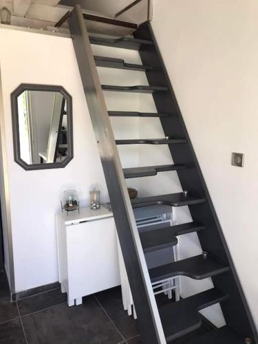 a spiral staircase in a room with a mirror at Au pied des gorges du blavet et à 20min des plages in Roquebrune-sur-Argens