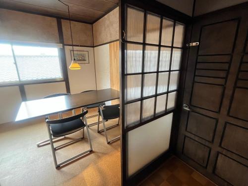 長崎的住宿－AKUNOURA HUIS，一间设有桌子和两把椅子的房间和一扇门