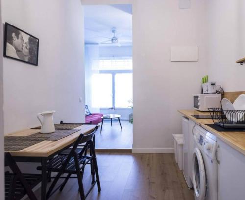 a kitchen with a table and a dining room at MEZZANINe GREEN in Madrid