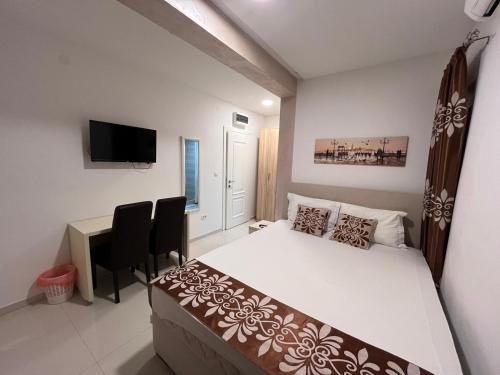 a bedroom with a bed and a desk and a television at Pearl Apartments in Budva