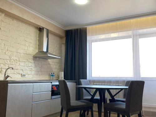 a kitchen with a table and chairs and a window at Skif HOTEL & SPA in Petropavlovsk
