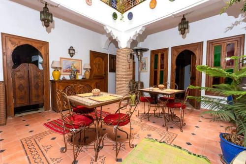una habitación con mesa y sillas en una casa en Riad Aquarelle By GE en Marrakech