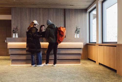 Hotel Lisl - Alpine Comfort في كوهتاي: شخصين واقفين أمام الكونتر