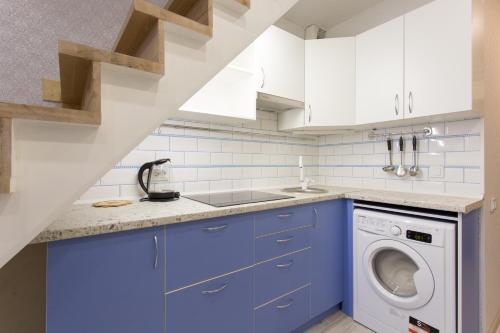 cocina con armarios azules, lavadora y secadora en NewStyle en Járkov