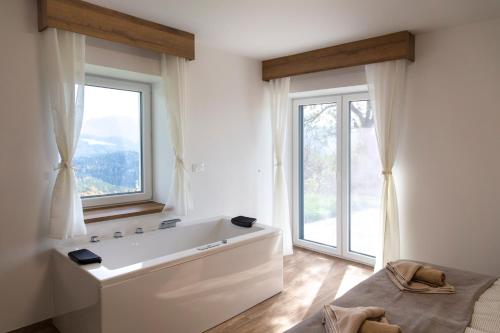 Vila Marin في Prevalje: حمام مع حوض استحمام و نافذة كبيرة
