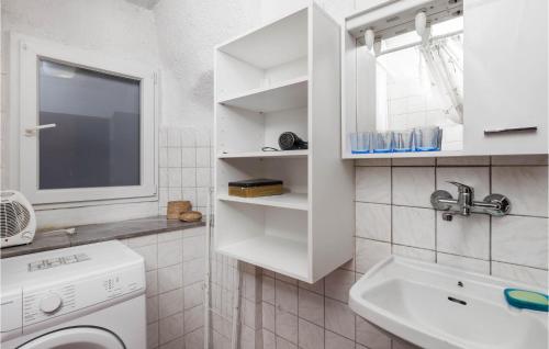 La salle de bains blanche est pourvue d'un lave-linge et d'un lavabo. dans l'établissement Beautiful Apartment In Kastav With House A Panoramic View, à Kastav