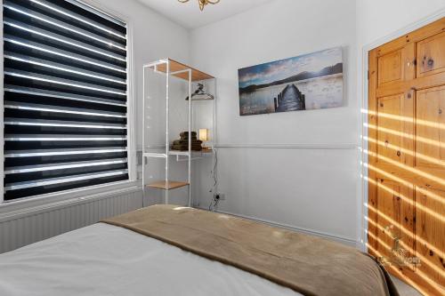 - une chambre avec un lit et une fenêtre avec des stores dans l'établissement Central Exeter Apartment (Kimberley 1A), à Exeter
