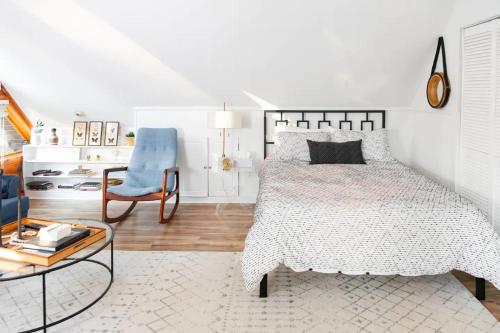 a bedroom with a bed and a chair and a table at HOT TUB Charming & Chic Mountain Gem On Sleepy Creek in Berkeley Springs
