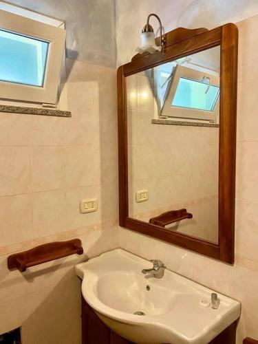 uma casa de banho com um lavatório e um espelho em Agriturismo Su Niu em Uta