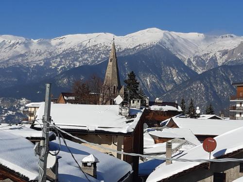 a small town with snow covered roofs and a church at Sauze d'Oulx ciabot la garitüla with garden - wifi- close to the chairlift in Sauze dʼOulx