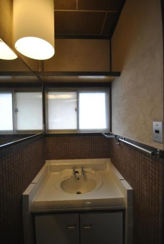 a bathroom with a sink and two windows at AKUNOURA HUIS in Nagasaki