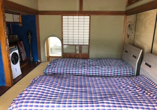 1 dormitorio con 2 camas en una habitación en Guesthouse Yadokari - Vacation STAY 90101 en Imabari