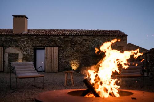 a fire pit in front of a building at Herdade dos Abegões in Salvaterra do Extremo