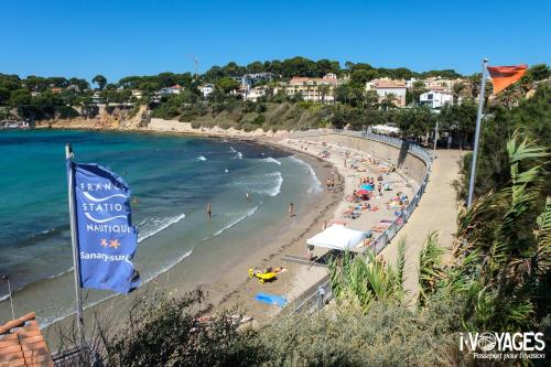 Ein Strand mit einem Haufen Leute im Wasser. in der Unterkunft Portissol - Le Printania in Sanary-sur-Mer