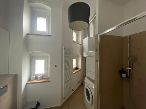 een badkamer met een wasmachine en een raam bij Spokojny Sen Quiet Rooms in Old Town in Poznań