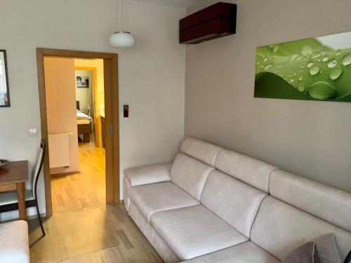 a living room with a white couch and a painting at Park - apartmány na prenájom in Nové Mesto nad Váhom