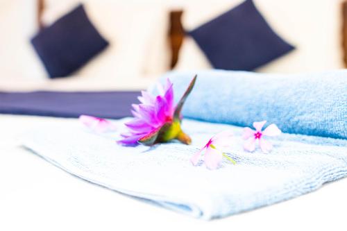 a pink flower sitting on top of a white towel at Shan Star Weligama in Weligama