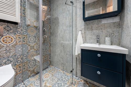 a bathroom with a blue sink and a shower at Apartament Południowy in Ruda Śląska