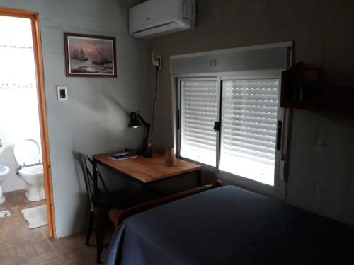 sypialnia z łóżkiem, biurkiem i oknem w obiekcie Excelente apartamento céntrico con cochera. w mieście Trinidad