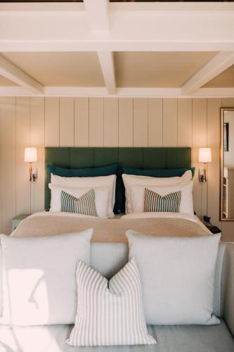 a bedroom with a large bed with white pillows at Engø Gård Hotel & Restaurant in Tjøme