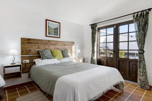a bedroom with a large bed and a window at Casa Los Angeles in Tías