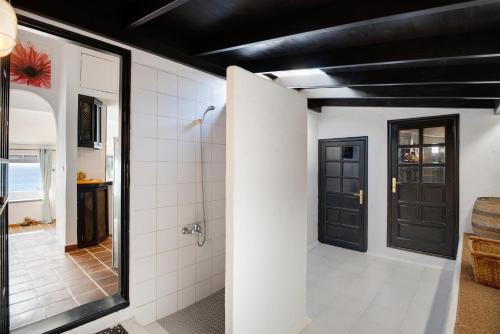 a bathroom with a walk in shower and black doors at Casa Los Angeles in Tías