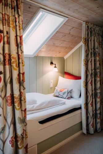 a bedroom with a bed with a skylight at Engø Gård Hotel & Restaurant in Tjøme