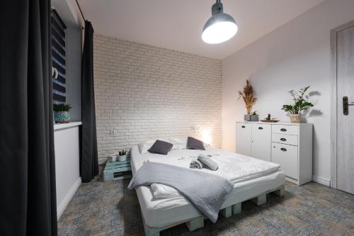 魯達希隆斯卡的住宿－Apartament Południowy，一间卧室设有一张床和砖墙