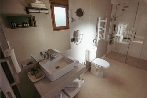 a white bathroom with a sink and a toilet at Natura Resorts in Casalarreina