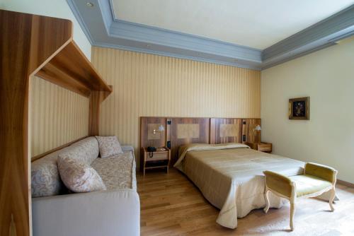 a bedroom with a bed and a couch at Villa Tuscolana in Frascati