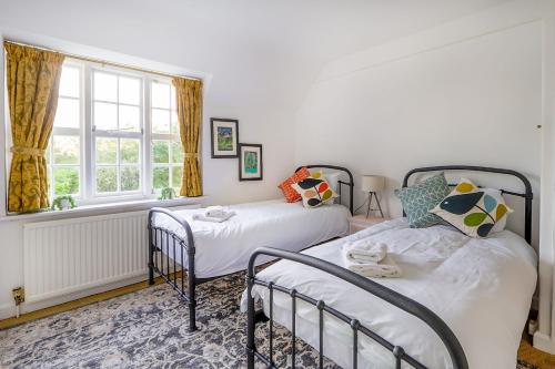 倫敦的住宿－Cheerful 3 bedroom luxury house，一间卧室设有两张床和窗户。