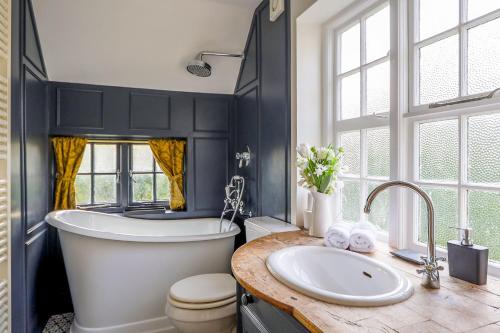 a bathroom with a tub and a toilet and a sink at Cheerful 3 bedroom luxury house in London