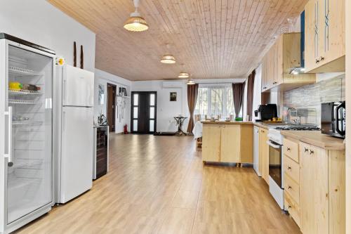 a large kitchen with white appliances and wooden floors at Casa Mamaia Pasa in Murighiol