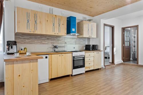 a kitchen with wooden cabinets and white appliances at Casa Mamaia Pasa in Murighiol