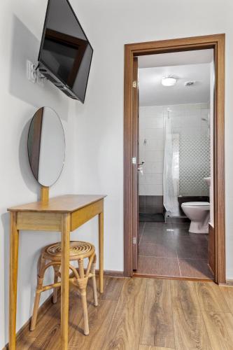 a bathroom with a table and a mirror and a sink at Casa Mamaia Pasa in Murighiol