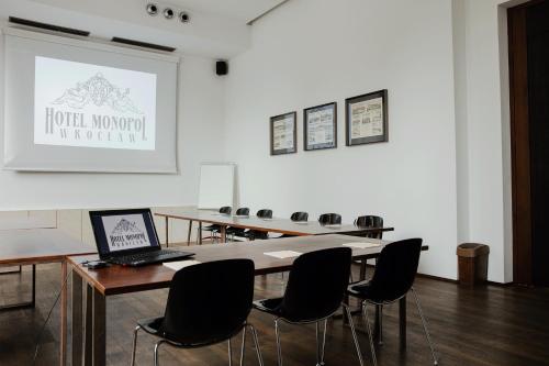 a conference room with a laptop on a table with chairs at Hotel Monopol in Wrocław
