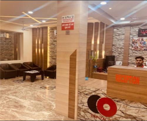 a man standing in a lobby with a reception desk at Hotel The Grand Tilak By WB Inn