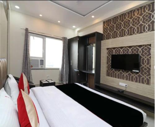 a bedroom with a large bed and a flat screen tv at Hotel The Grand Tilak By WB Inn