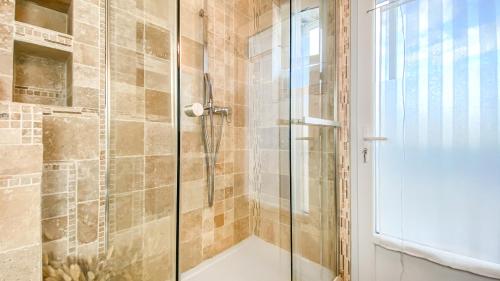 a bathroom with a shower with a glass door at HOMEY HANNA - Au pied du tram / Parking gratuit / Balcon privé / Wifi gratuit in Annemasse