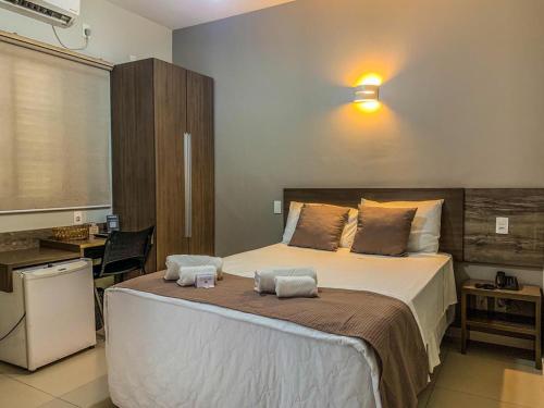 ein Schlafzimmer mit einem großen Bett mit zwei Handtüchern darauf in der Unterkunft Hotel Piratininga Fernando Corrêa - Rondonópolis in Rondonópolis