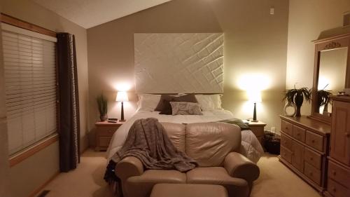 a bedroom with a bed and a couch and two lamps at Lakeville Executive Home with every amenity, prime location in Lakeville