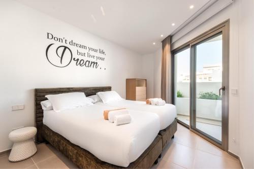 a bedroom with a large bed with a sign on the wall at Jardines - Tisaya 11 POOL VIEW & TWIN BEDS 1B in Palm-mar