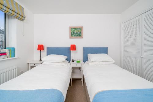 two beds sitting next to each other in a room at ALTIDO Cosy 2 bed, 2 bath flat with terrace, close to Tower Bridge in London