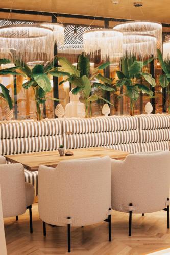 a restaurant with tables and chairs and chandeliers at White Hill Hotel, SPA & Conferences in Durrës
