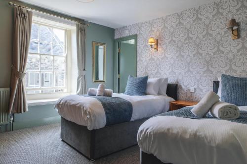リッチモンドにあるBlack Lion Hotel Richmond North Yorkshireのベッド2台と窓が備わるホテルルームです。